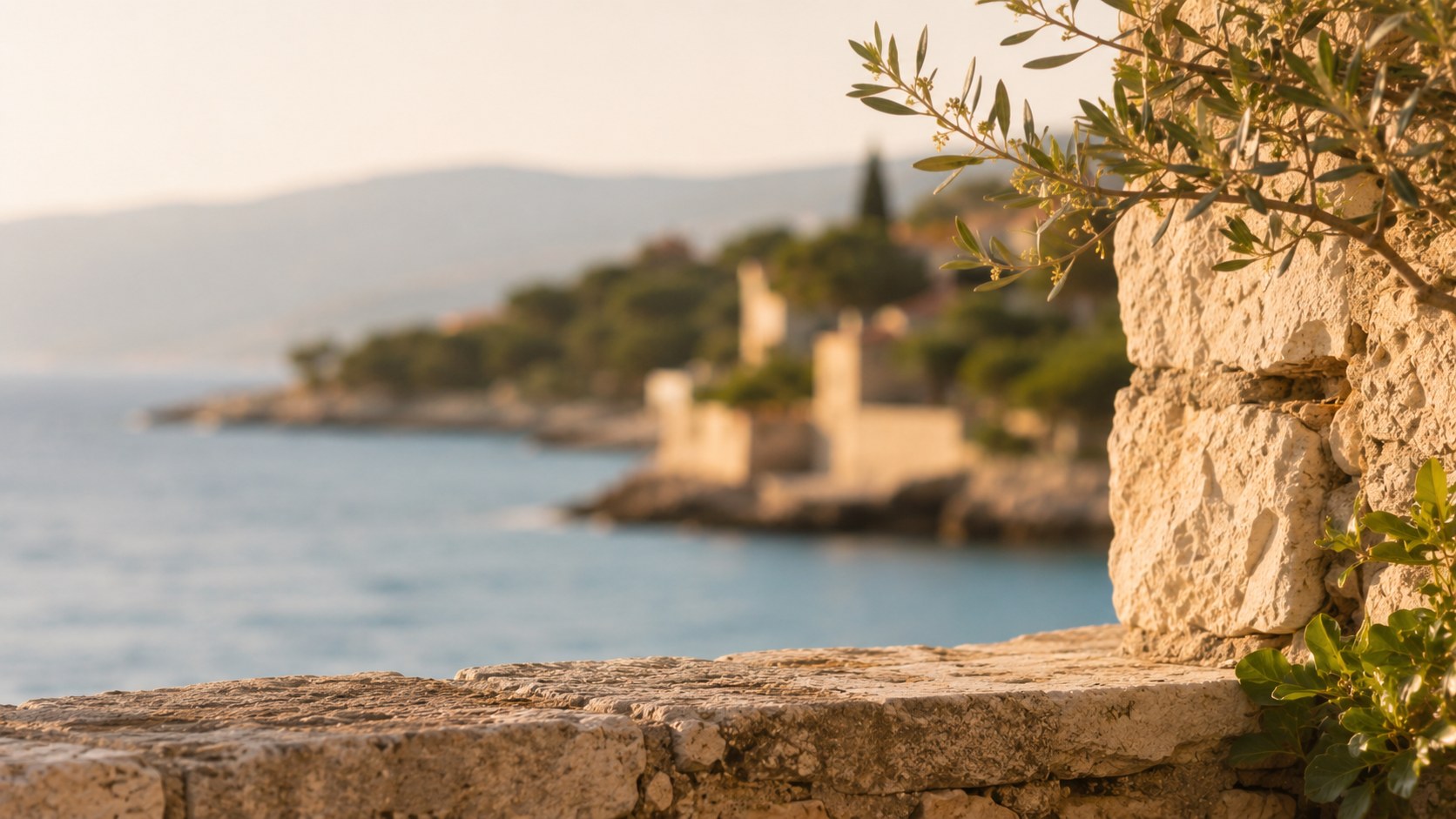 Steinmauer mit Olivenzweig und Meerblick auf den kroatischen Inseln Cres und Lošinj.